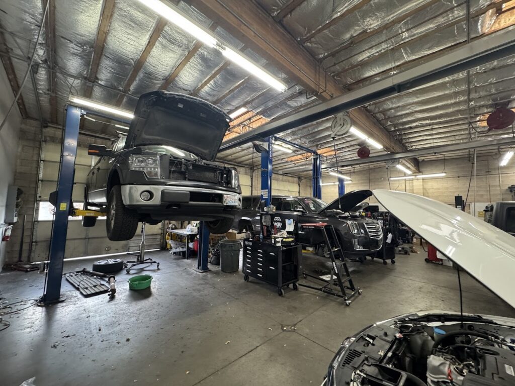 Vehicles on lifts inside Reno Auto Works service bays